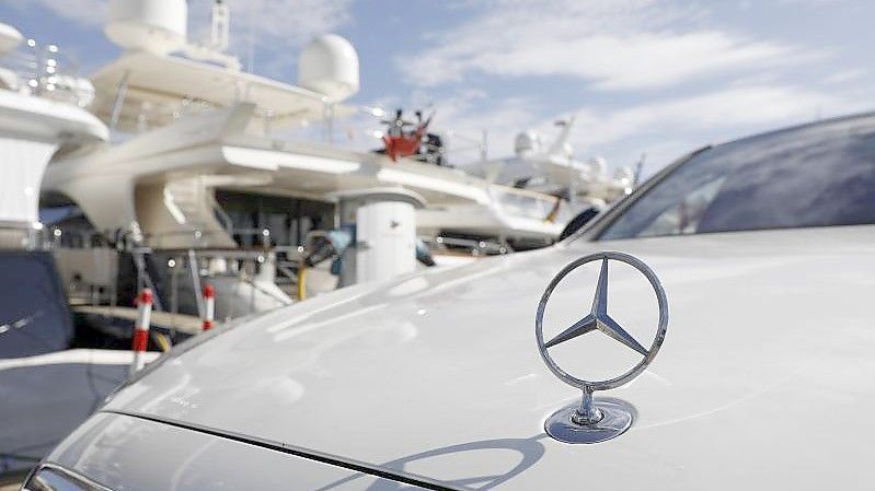 Eine Mercedes Limousine steht im Hafen von Puerto Portals vor Yachten. Lange wurde Mallorca als „Putzfrauen-Insel“ verspottet, dann wurde sie für „Sauftouristen“ geschmäht. Plötzlich erlebt die Insel einen Ansturm der Reichen. Foto: Clara Margais/dpa