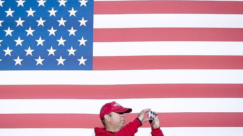 Ein Mann macht Bilder, während er auf die Ankunft des republikanischen Gouverneurskandidaten Glenn Youngkin bei einer Wahlkampfveranstaltung in Leesburg, Virginia, wartet. Foto: Cliff Owen/AP/dpa