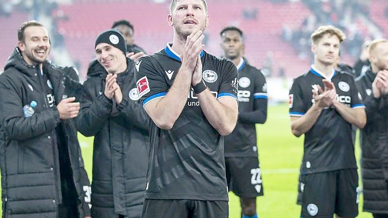 Fabian Klos (M) und Kollegen lassen sich nach dem ersten Saisonsieg von ihren Fans feiern. Foto: Tom Weller/dpa