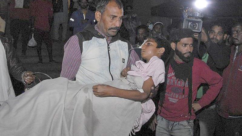 Ein Mann trägt ein Kind aus dem Kamla Nehru Children's Hospital im indischen Bhopal. Foto: Uncredited/AP/dpa