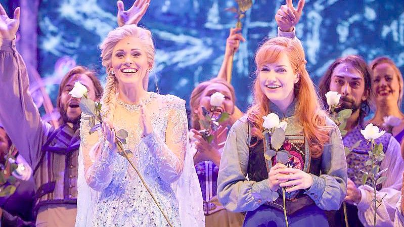 Sabrina Weckerlin als Eiskönigin Elsa und Celena Pieper als Anna nach der Deutschlandpremiere des Disney-Musicals "Die Eiskönigin" in Hamburg. Foto: Christian Charisius/dpa