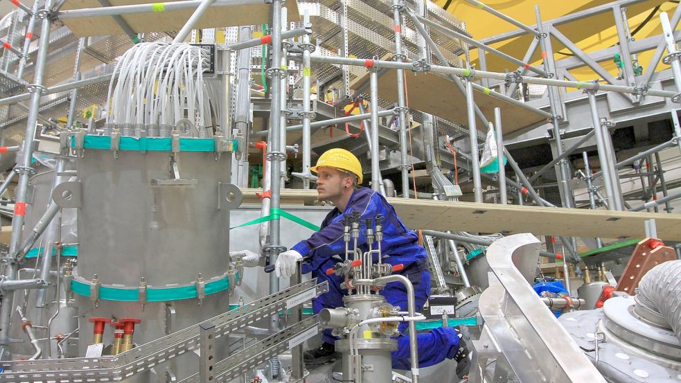 Ein Mitarbeiter des Max-Planck-Instituts für Plasmapyhsik in Greifswald arbeitet an einem Versuchs-Fusionsreaktor. Foto: imago images/BildFunkMV