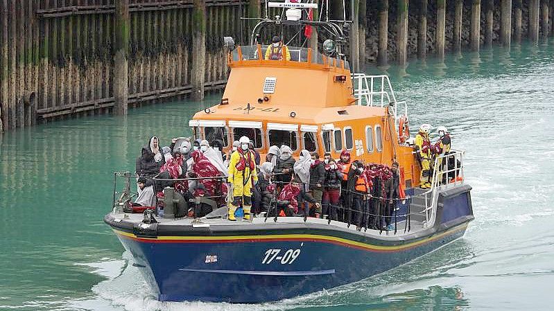 Eine Gruppe von Menschen, bei denen es sich vermutlich um Migranten handelt, wird an Bord des Dover-Rettungsboots an Land gebracht. Foto: Gareth Fuller/PA Wire/dpa