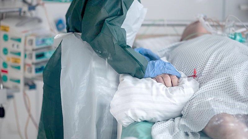 Eine Mitarbeiterin der Pflege betreut einen Covid-Patienten im nordrhein-westfälischen Essen. Die Gesamtzahl der nachgewiesenen Corona-Infektionen in Deutschland hat die Fünf-Millionen-Marke überschritten. Foto: Fabian Strauch/dpa