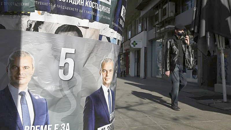 Ein Mann geht in Bulgariens Haupstadt Sofia an einem Wahlplakat von Spitzenkandidat Kostadin Kostadinov vorbei. Foto: Giannis Papanikos/AP/dpa