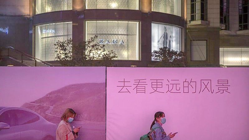 Passanten am Einkaufszentrum Pekings: Der Einzelhandelsumsatz zog im Vergleich zu Oktober um 4,9 Prozent an. Foto: Mark Schiefelbein/AP/dpa