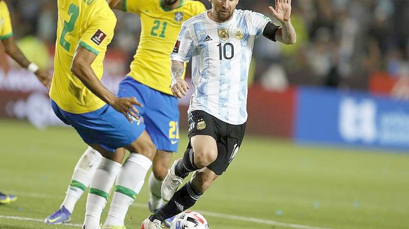 Lionel Messi (r) aus Argentinien in Aktion gegen Matheus Cunha (hinten) und Danilo (l) aus Brasilien. Foto: Gustavo Ortiz/dpa