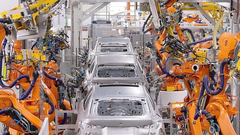 Roboter arbeiten an der Karosserie von verschiedenen BMW-Modellen im Münchner Stammwerk. Nach Einschätzung ausländischer Konzerne hat Deutschland bei wichtigen Standortfaktoren wie Steuern und Digitalisierung im EU-Vergleich weiter an Wettbewerbsfähigkeit verloren. Foto: Sven Hoppe/dpa