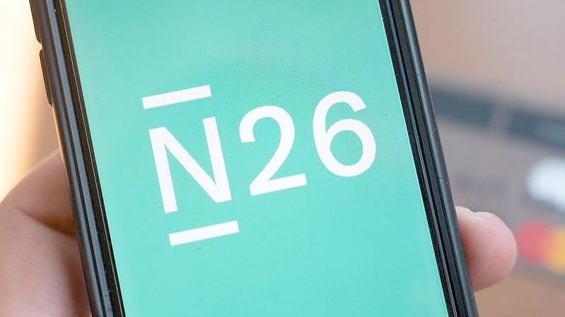 Das Logo der Smartphone-Bank N26 ist auf einem Smartphone eingeblendet. Foto: Christophe Gateau/dpa/Smybolbild