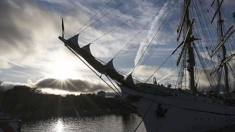 Die „Gorch Fock“ liegt im Gegenlicht an ihrem Liegeplatz in Kiel. (Archivbild). Foto: Frank Molter/dpa