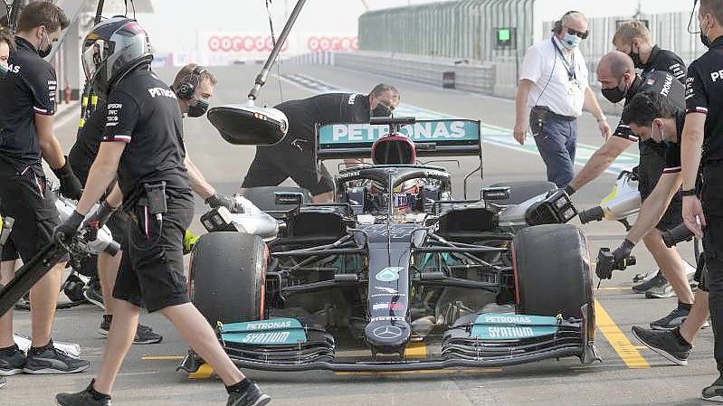 Mechaniker arbeiten bei einem Boxenstopps während des Trainings am Auto von Lewis Hamilton. Foto: Darko Bandic/AP/dpa