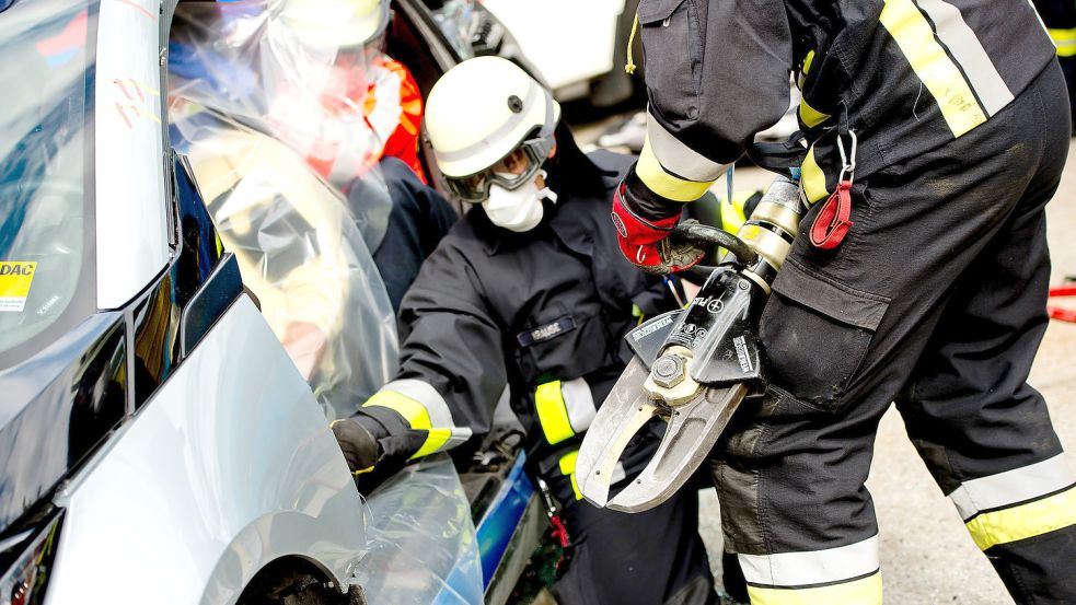 Feuerwehrleute zerschneiden bei einer Übung mit einer Rettungsschere ein Auto. Symbolfoto: Sven Hoppe/DPA