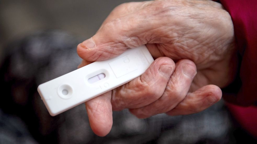 Eine Seniorin hält einen Corona-Schnelltest in der Hand. Symbolfoto: DPA