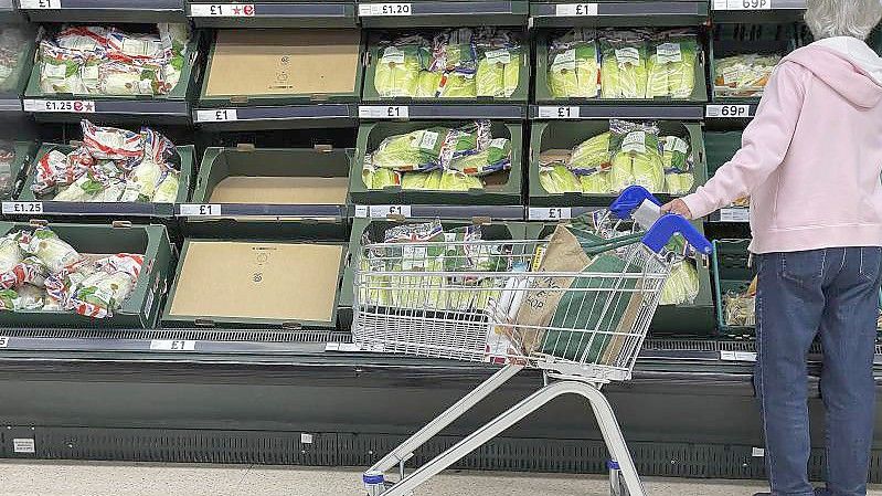 Eine Frau steht vor teilweise leeren Regalen in einem Supermarkt in London. Foto: Frank Augstein/AP/dpa