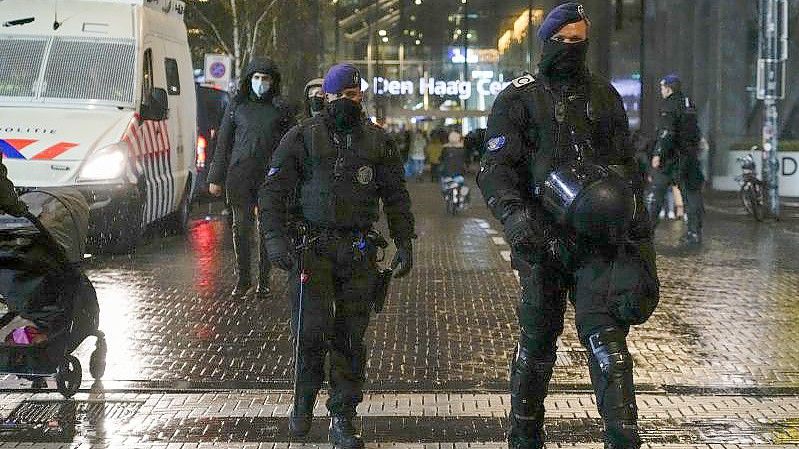 Niederländische Polizisten patrouillieren vor einem Ministeriumsgebäude. Foto: Peter Dejong/AP/dpa