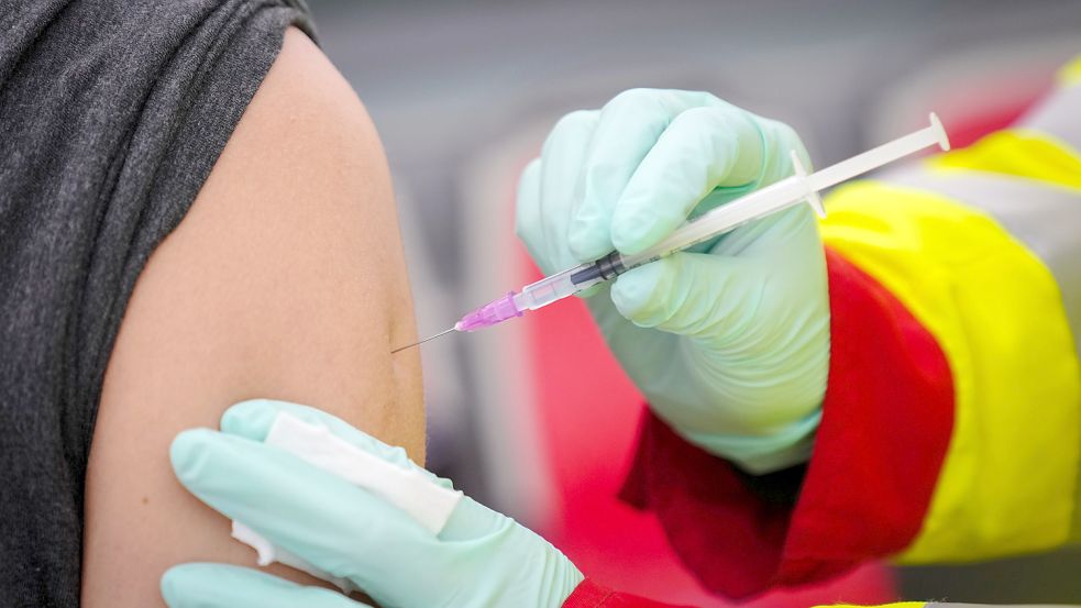 Ein Arzt setzt eine Spritze mit dem Impfstoff gegen das Coronavirus. Foto: DPA