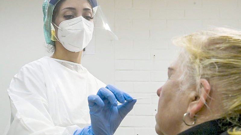 Eine medizinische Mitarbeiterin testet eine Frau auf das Coronavirus in einer Corona-Teststelle. Foto: Markku Ulander/Lehtikuva/dpa