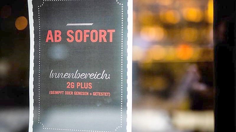 Ein Plakat weist Gäste am Eingang eines Restaurants in Stuttgart auf die neue 2G Plus Regel hin. Foto: Christoph Schmidt/dpa