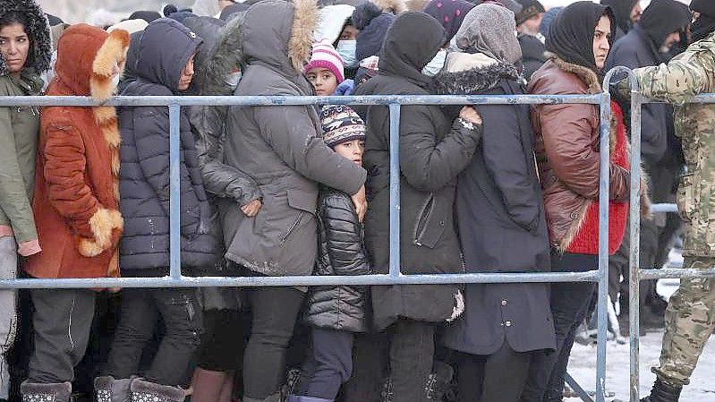 Das von der belarussischen Staatsagentur BelTA zur Verfügung gestellte Foto zeigt Migranten, die in einem Logistikzentrum an der belarussisch-polnischen Grenze für Essen anstehen. Foto: Oksana Manchuk/BelTA/AP/dpa