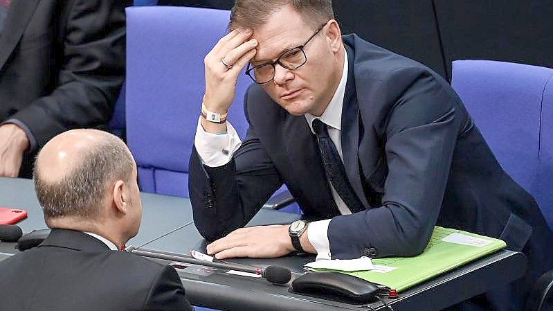 Der nächste Bundeskanzler Olaf Scholz (l) spricht im Bundestag mit Carsten Schneider (Archivbild). Foto: Britta Pedersen/dpa-Zentralbild/dpa