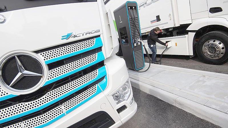 Ein Mitarbeiter der Daimler AG steckt einen Ladestecker in einen elektrisch angetriebenen Mercedes-Benz eActros. Foto: Marijan Murat/dpa