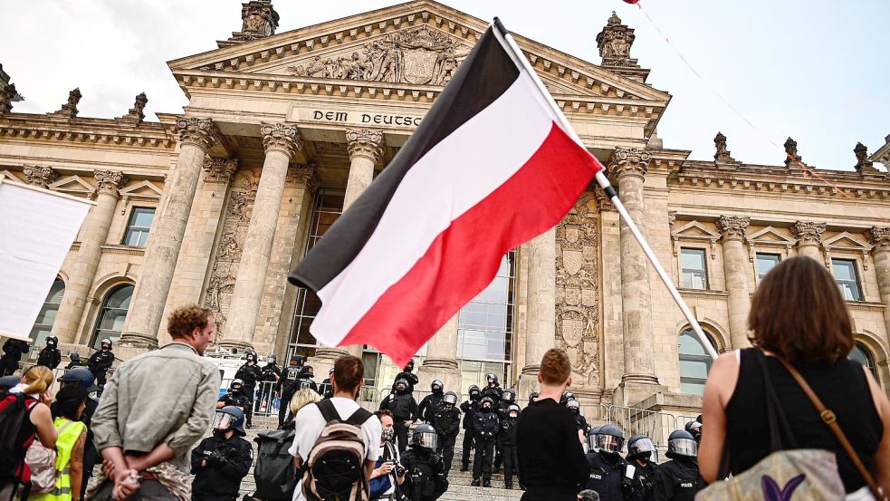 Querdenker und Impfgegner vernetzen sich bei Telegram und gehen gemeinsam auf die Straße. Bereits im Sommer standen Teilnehmer einer Demonstration gegen die Corona-Maßnahmen mit einer Reichsflagge vor dem Reichstag. Foto: Fabian Sommer/dpa