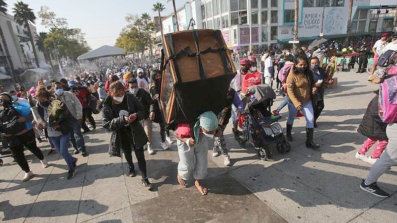 Ein Gläubiger ist mit einer Statue auf dem Rücken auf Pilgerfahrt gegangen. Foto: Ginnette Riquelme/AP/dpa