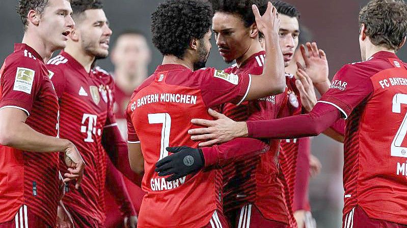 Bayerns Serge Gnabry (M, l) jubelt mit Leroy Sané und weiteren Mitspielern über seinen Treffer zur 2:0-Führung in Stuttgart. Foto: Tom Weller/dpa