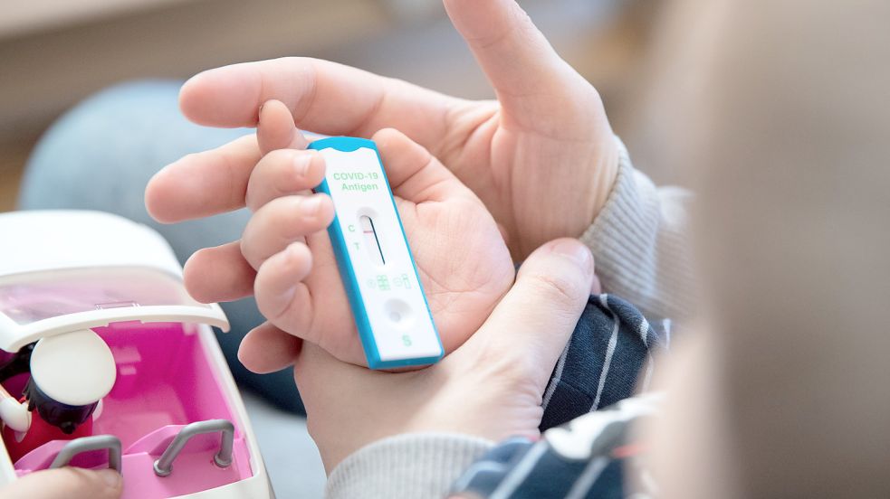 Eine Mutter kontrolliert mit ihrem Kind einen Corona-Schnelltest. Archivfoto: DPA