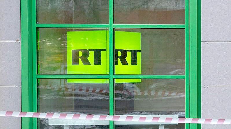 Das Logo des staatlichen russischen TV-Senders „Russia Today“ (RT) ist im Fenster des Firmenbüros zu sehen. Die Videoplattform Youtube hat erneut einen deutschsprachigen Kanal des russischen Staatssenders RT entfernt. Foto: Pavel Golovkin/AP/dpa
