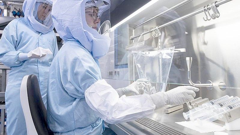 Laborantinnen der Firma Biontech simulieren die finalen Arbeitsschritte zur Herstellung des Corona-Impfstoffes an einem Bioreaktor. Foto: Boris Roessler/dpa