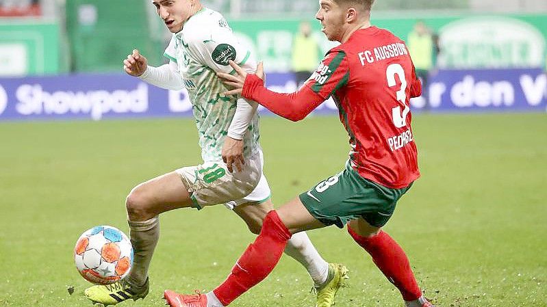 Der Fürther Marco Meyerhöfer (l) kämpft mit dem Augsburger Mads Pedersen um den Ball. Foto: Daniel Karmann/dpa