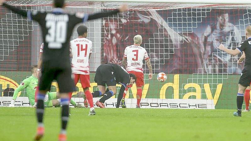 RB-Torwart Peter Gulacsi kann den Schuss von Bielefelds Janni Serra (M) nicht halten. Die Arminia gewinnt in Leipzig mit 2:0. Foto: Jan Woitas/dpa-Zentralbild/dpa