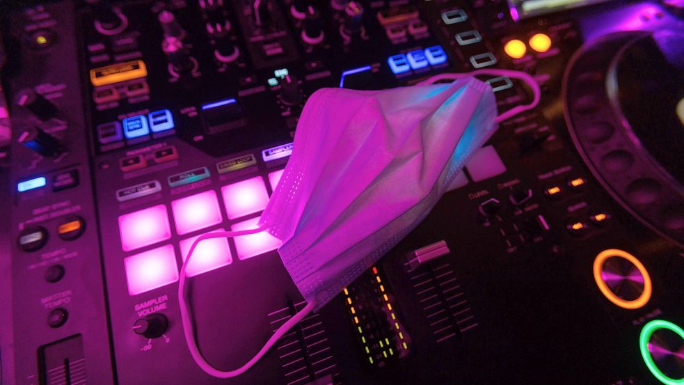 Ein Mund-Nasen-Schutz liegt auf dem Mischpult des DJs in einem Club. Foto: DPA