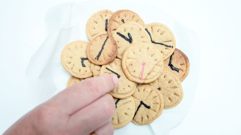 Kekse in Uhrenform liegen auf einem Haufen. Foto: DPA
