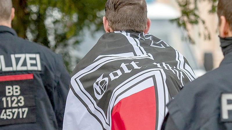 Ein Mann wird während einer Demonstration von sogenannten Reichsbürgern von der Polizei abgeführt. Foto: Christophe Gateau/dpa