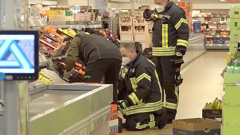 Einsatzkräfte der Polizei, Feuerwehr und ein Spinnenexperte suchen in den Obst- und Gemüseregalen des Supermarktes nach dem Tier. Foto: Nord-West-Media/Nord-West-Media /dpa