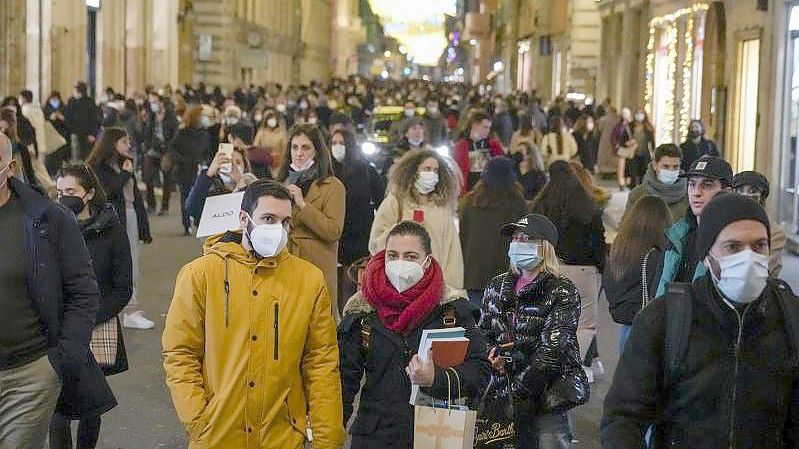 Menschen gehen durch eine Einkaufsstraße in Rom. In Italien sind die Corona-Zahlen erneut in die Höhe geschossen. Foto: Andrew Medichini/AP/dpa