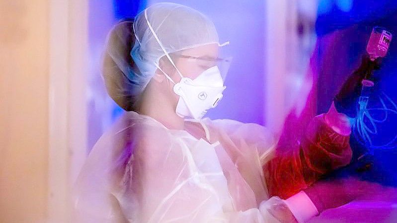 Eine Intensivfachpflegerin betreut auf der Intensivstation des Gemeinschaftskrankenhauses Havelhöhe einen Covid-19-Patienten. Foto: Christoph Soeder/dpa