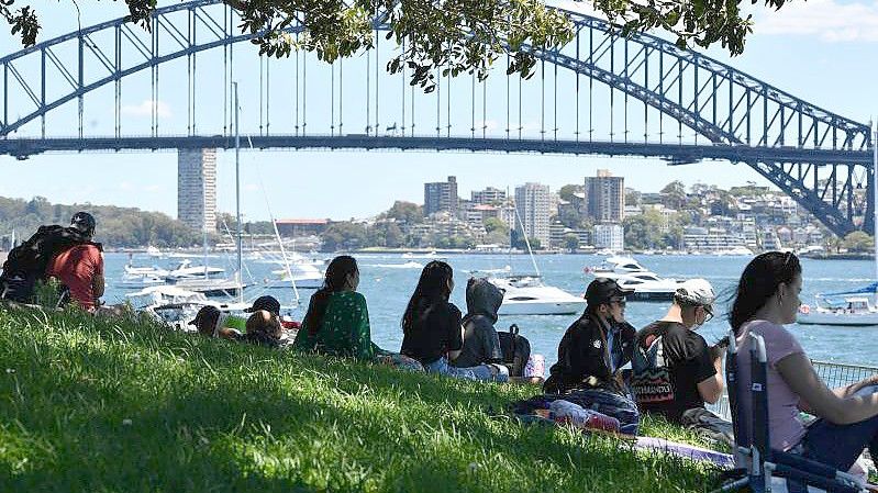 Vor den Silvesterfeierlichkeiten in Sydney versammelt sich eine kleine Menschenmenge an einem Aussichtspunkt mit Blick auf die Harbour Bridge. Foto: Dean Lewins/AAP/dpa