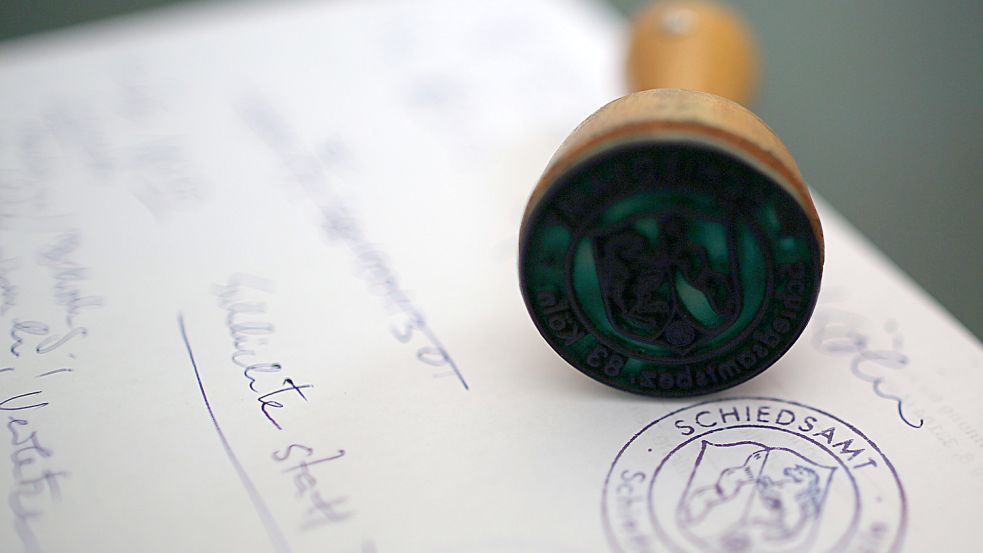 Der Stempel eines Schiedsamtes liegt auf einem Papier. Symbolfoto: DPA