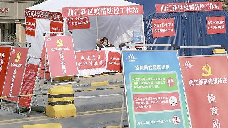 Eine Mitarbeiterin der Regierung an einem Kontrollpunkt vor einem Wohnblock in der Stadt Xi'an. Foto: Uncredited/CHINATOPIX/AP/dpa