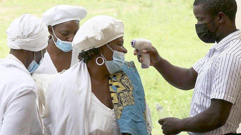 In Simbabwes Hauptstadt Harare lassen Menschen ihre Temperatur überprüfen. Foto: Tsvangirayi Mukwazhi/AP/dpa