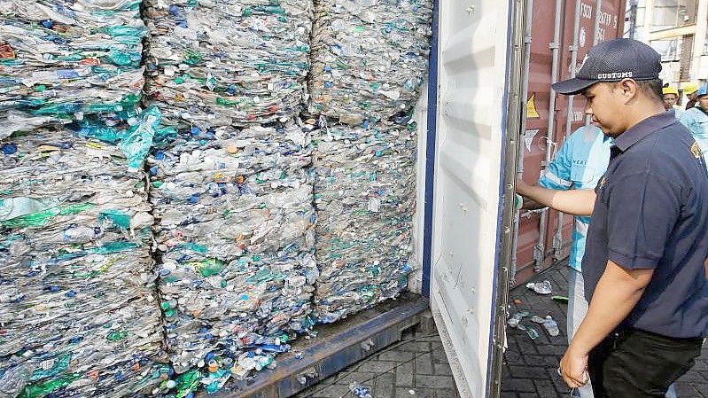 Ein Zollbeamter verschließt am Hafen von Tanjung Priok einen Container mit Plastikmüll. Foto: Achmad Ibrahim/AP/dpa