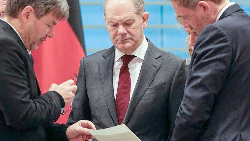 Bundeskanzler Olaf Scholz (m.) im Gespräch mit Wirtschaftsminister Robert Habeck (l.) und Finanzminister Christian Lindner. Foto: Omer Messinger/AFP/dpa