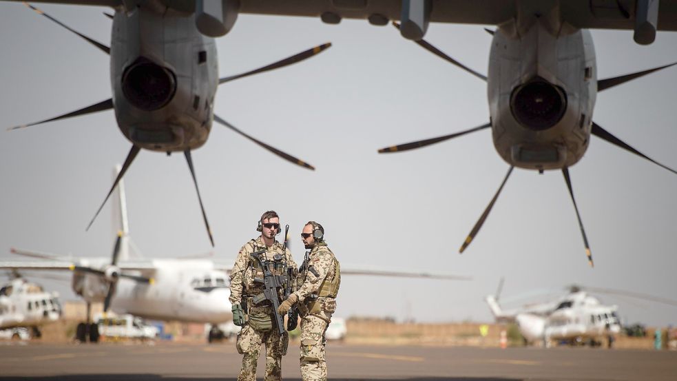 Einsatz in Mali: Deutsche Soldaten stehen am Flughafen in Gao und sichern ein Transportflugzeug. Foto: Arne Immanuel Bänsch/picture alliance/dpa