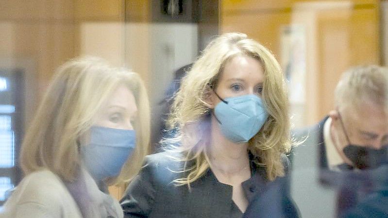 Elizabeth Holmes (M) betritt das Bundesgericht in San Jose, Kalifornien. Die einstige Vorzeigeunternehmerin Elizabeth Holmes ist von US-Geschworenen des Betrugs an mehreren ihrer Investoren schuldig gesprochen worden. Foto: Nic Coury/AP/dpa