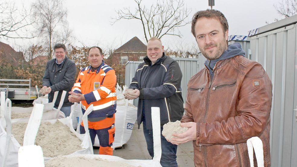 Carsten Siebels aus Walle (von rechts) spendete den Sand, Thorsten Uphoff von Siebels Baustoffe Norden kümmerte sich um die Verteilung und Bauhofleiter Timo Tönjes sowie Samtgemeindebürgermeister Gerhard Ihmels nahmen das Spielmaterial am Donnerstag in Empfang. Foto: Karin Böhmer