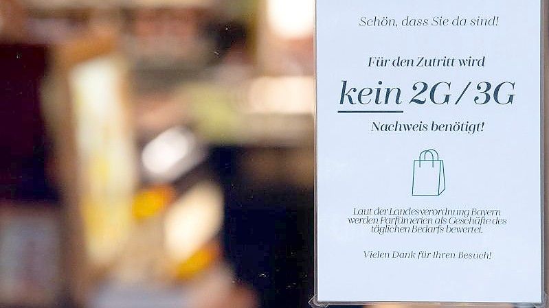 Ein Schild mit der Aufschrift „Für den Zutritt wird kein 2G/3G Nachweis benötigt“ hängt im Schaufenster eines Münchner Geschäfts. Foto: Sven Hoppe/dpa