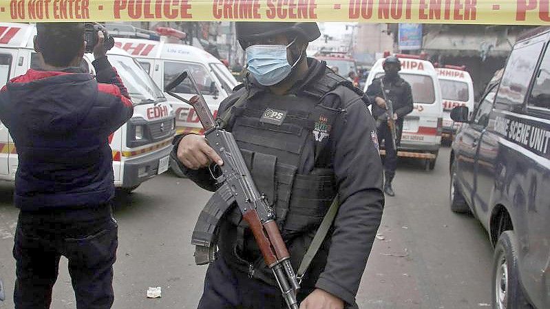 Polizisten stehen am Anschlagsort in Lahore, während Krankenwagen darauf warten Verletzte abzutransportieren. Foto: K.M. Chaudary/AP/dpa